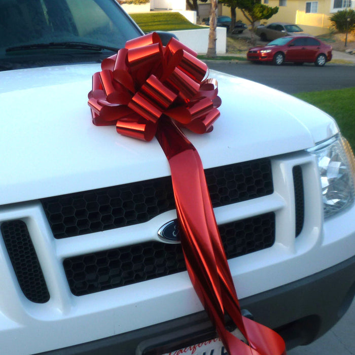 big metallic red bow on a white car