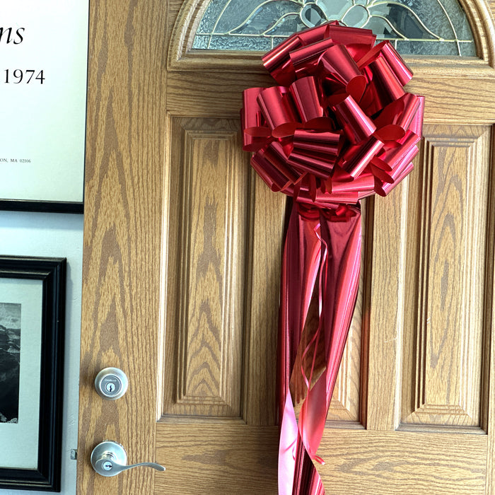 metallic red bow hanging on a door